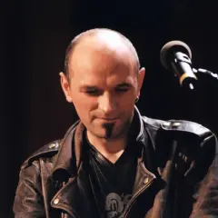 Artysta w skórzanej kurtce, z mikrofonem przed sobą. To jego pierwsze wykonanie, które warto przeżyć samemu.