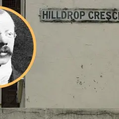 Czarno-białe zdjęcie mężczyzny w okularach i wąsach obok tabliczki z napisem "HILLDROP CRESCENT.N.".