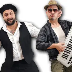 Dwóch mężczyzn w zabawnych strojach, jeden z beretem i kamizelką, drugi z kapeluszem i keyboardem na ramieniu, gotowi na figo fago.