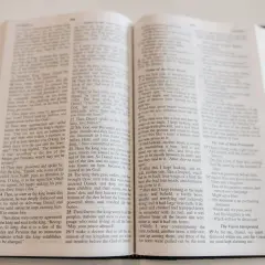 Otwarta Biblia, na jej stronach widnieje tekst, który może być fragmentem pieśni lub hymnu kościelnego.