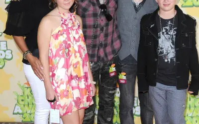 Chester Bennington dzieci: córka w kwiecistej sukience i syn w czarnej kurtce na czerwonym dywanie.