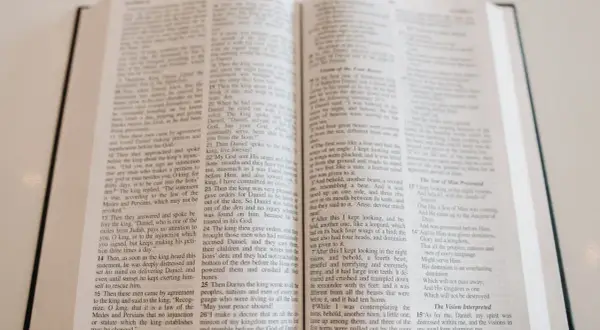 Otwarta Biblia, na jej stronach widnieje tekst, który może być fragmentem pieśni lub hymnu kościelnego.