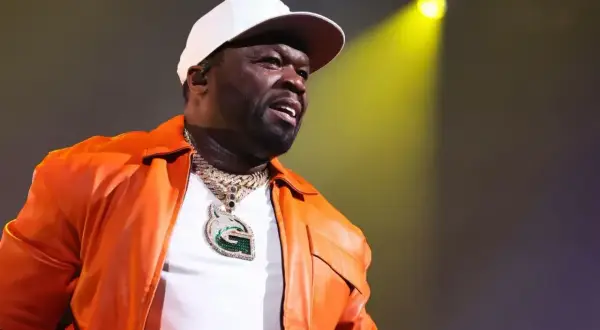 50 Cent w pomarańczowej kurtce i białej czapce, z naszyjnikiem z literą G. Czy to jego 21 pytań do fanów?