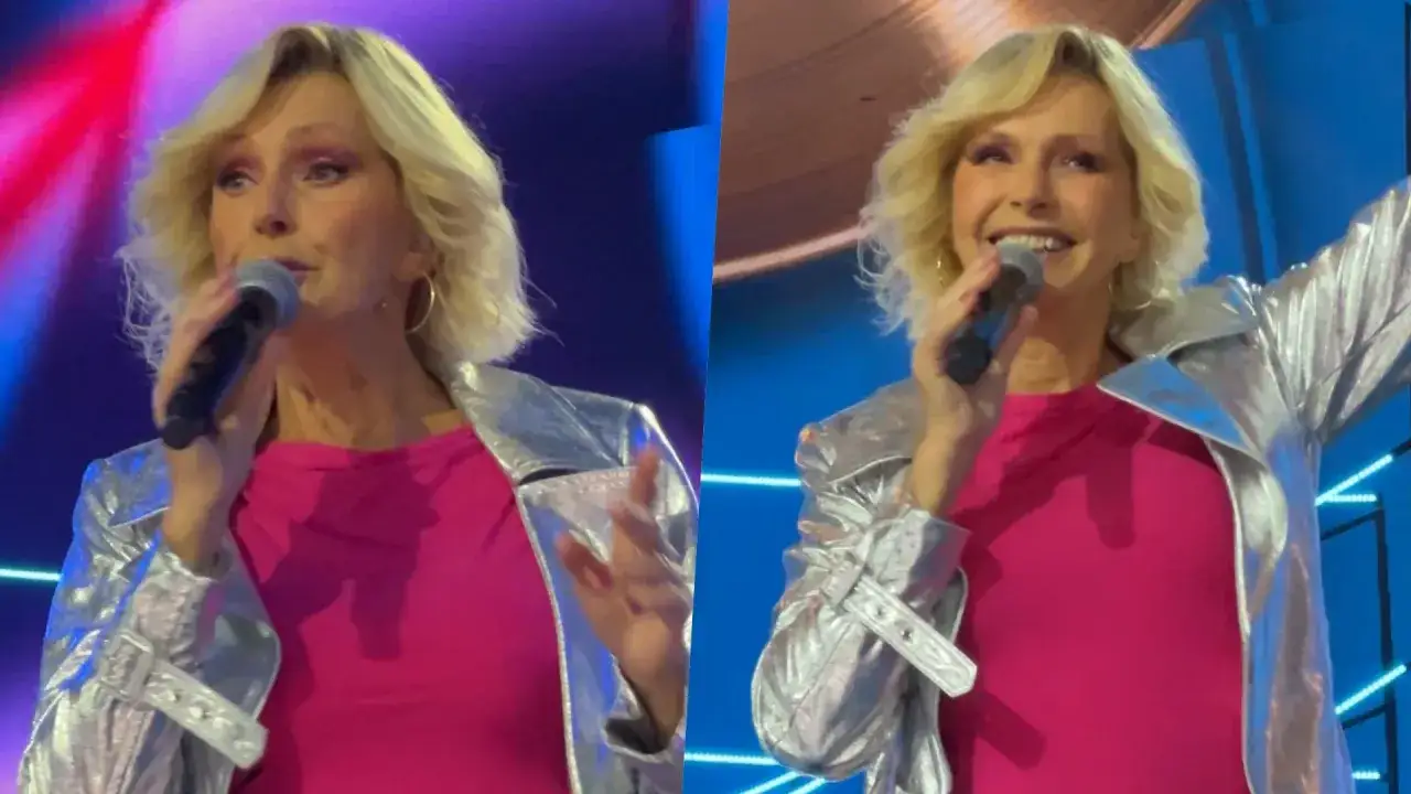 Helena Vondráčková w srebrnej kurtce i różowej sukience śpiewa na scenie, trzymając mikrofon.
