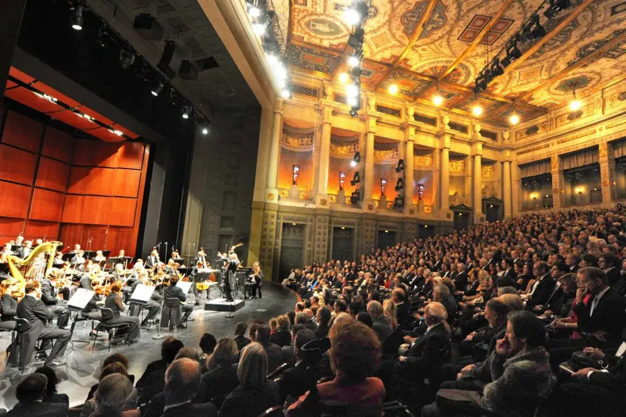 Orkiestra gra w zabytkowej sali koncertowej, a publiczność słucha tej pięknej serenady.