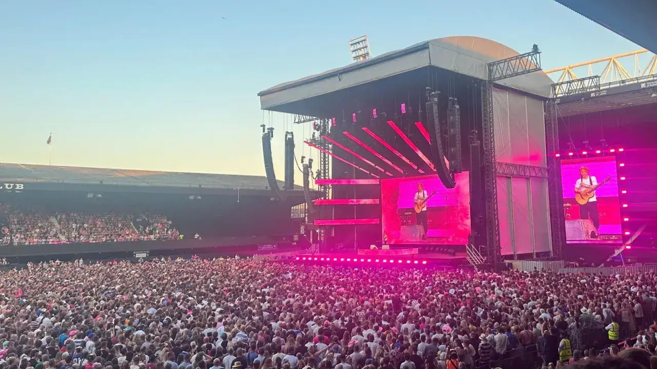 Tłum na stadionie śpiewa z Edem Sheeranem, gdy ten gra na gitarze, wykonując swój największy przebój.
